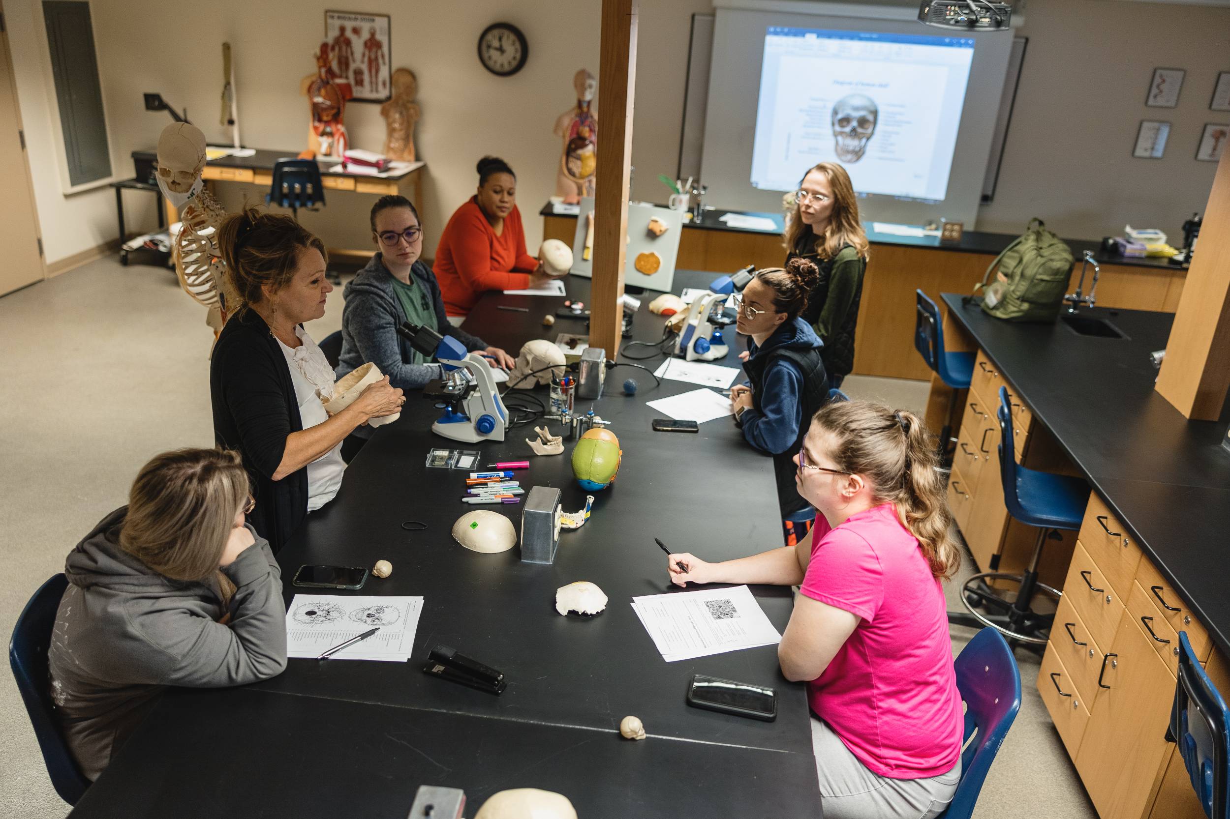 Students listen to an instructor in a science lab