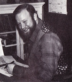 Bob Brown sitting at a desk, looking at the camera and smiling.