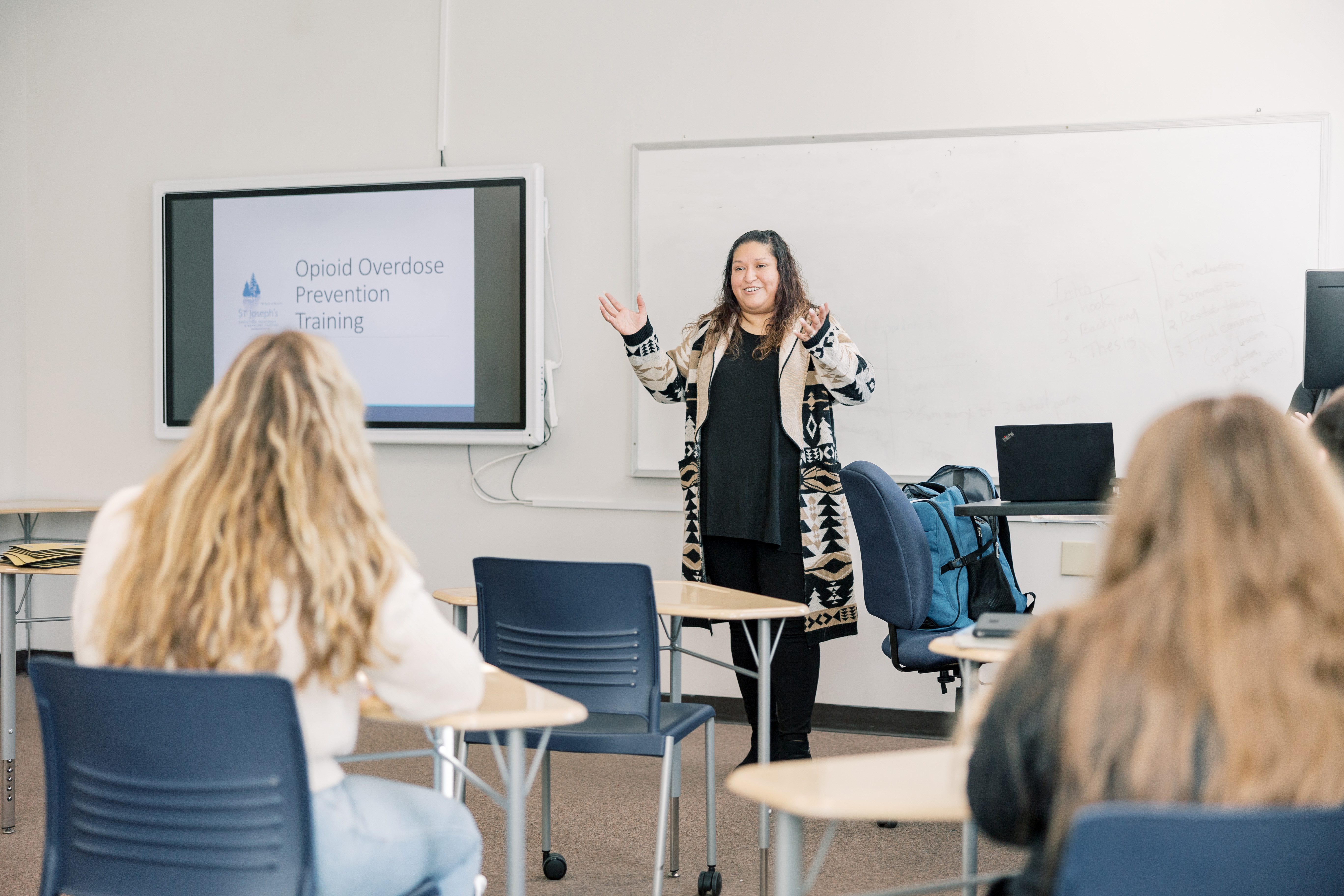 A teacher stands in front of a class leading a lesson.