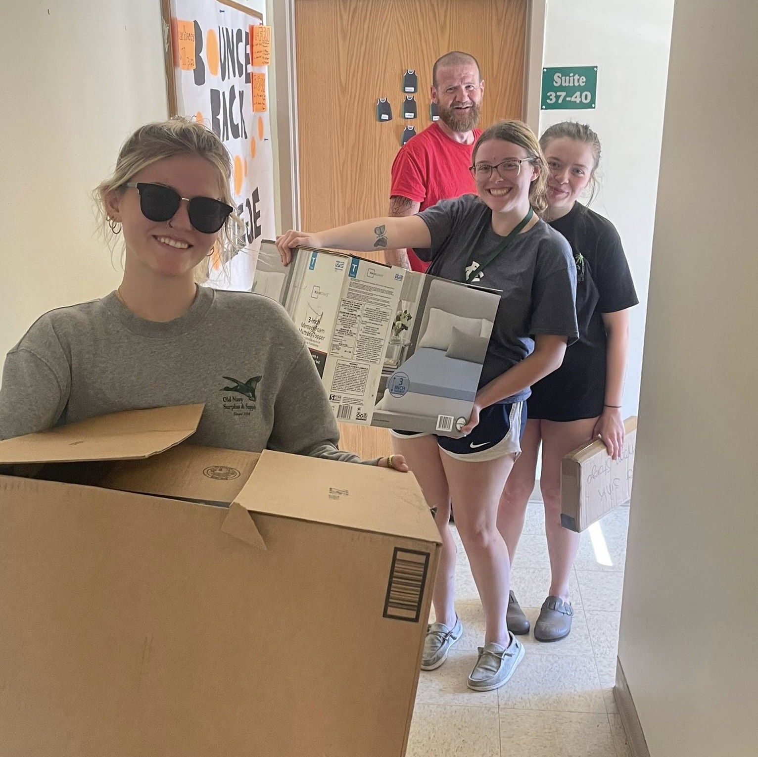 Students hold boxes as they move into a college dorm