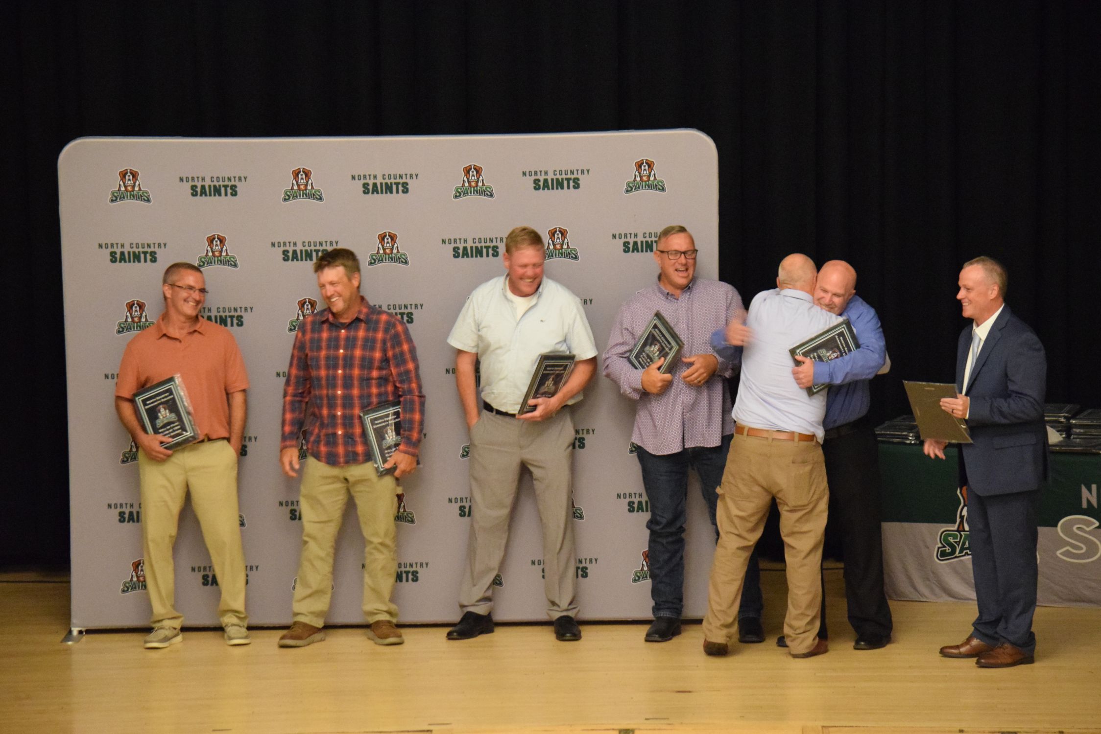 A group of men accept awards on a stage