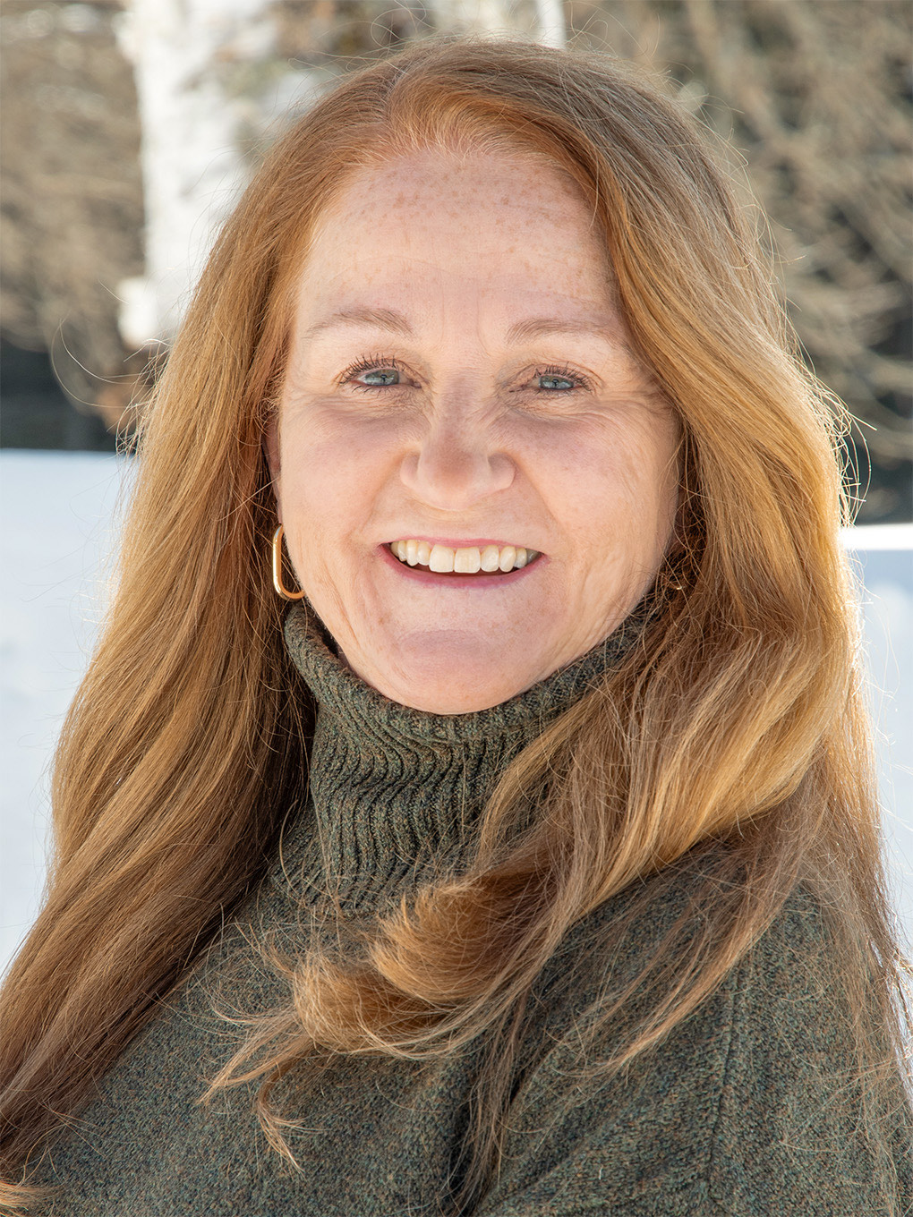 An up-close photo of Tricia Preston set against a winter backdrop