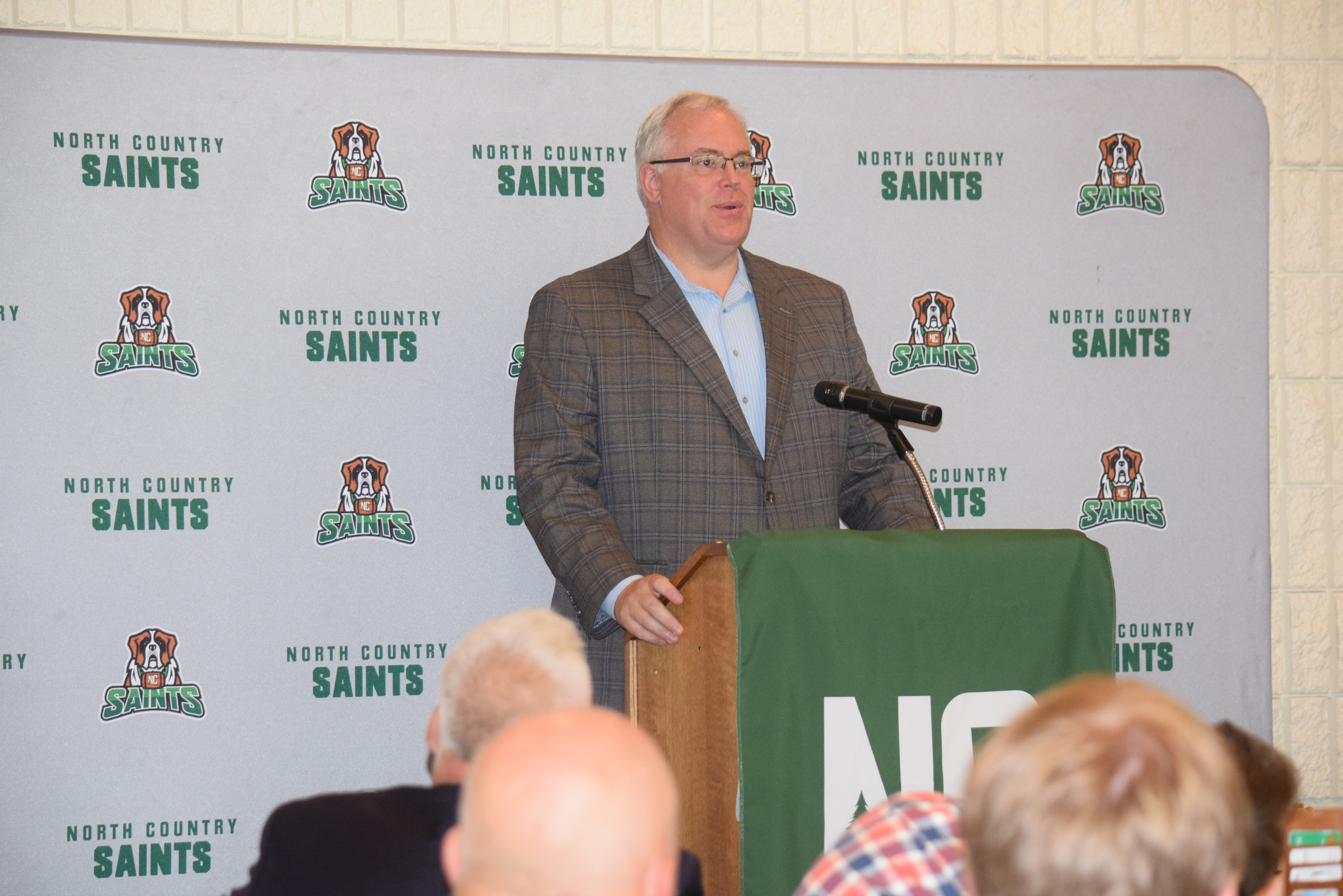 Dan Stec stands at a podium speaking to an audience