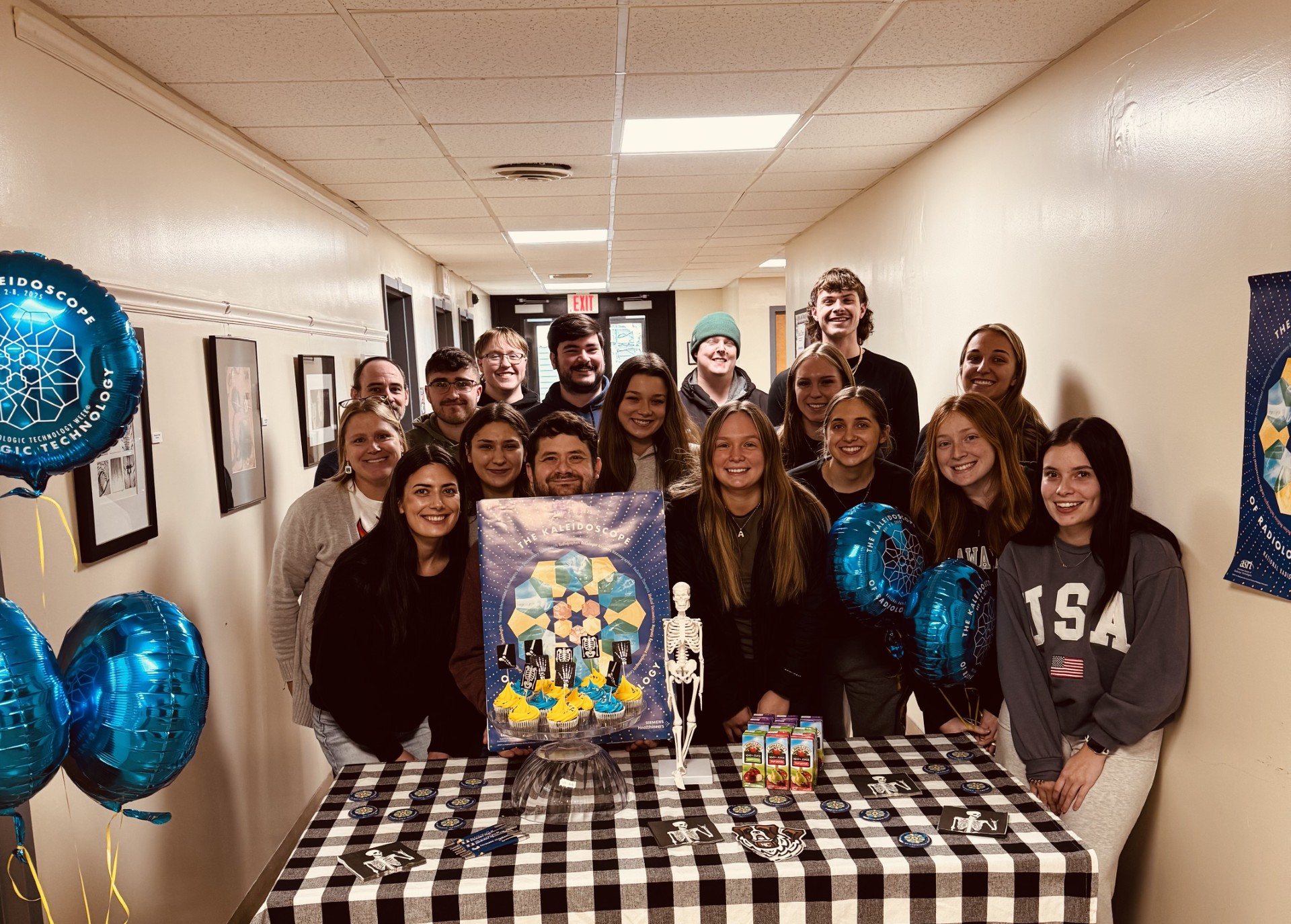 Students stand in a hallway smiling for the camera