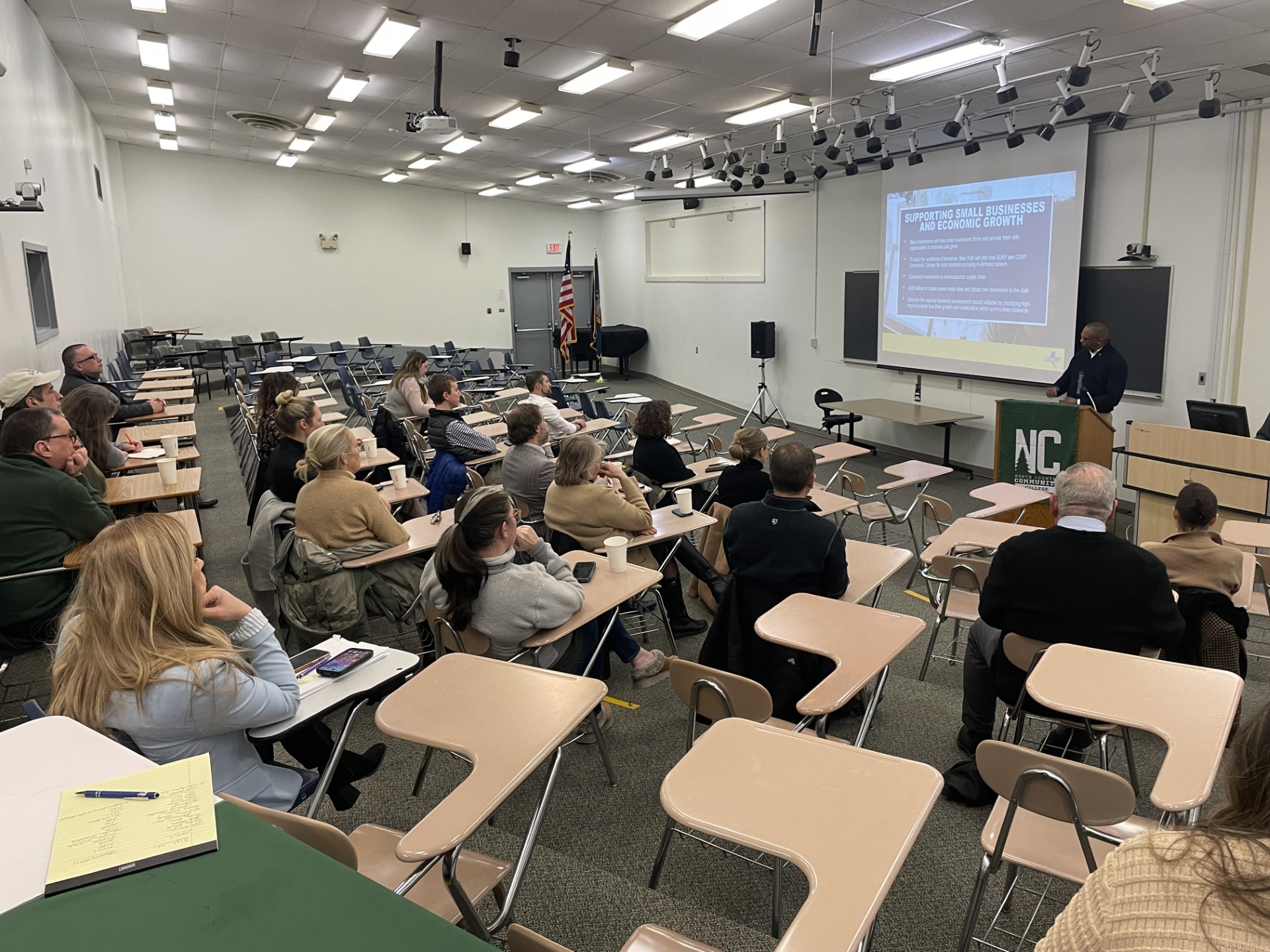 A speaker addresses a classroom full of people