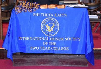 A Phi Theta Kappa banner draped over a table