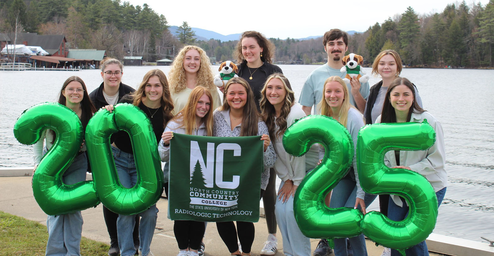 Rad Tech students stand in front of a lake smiling at the camera