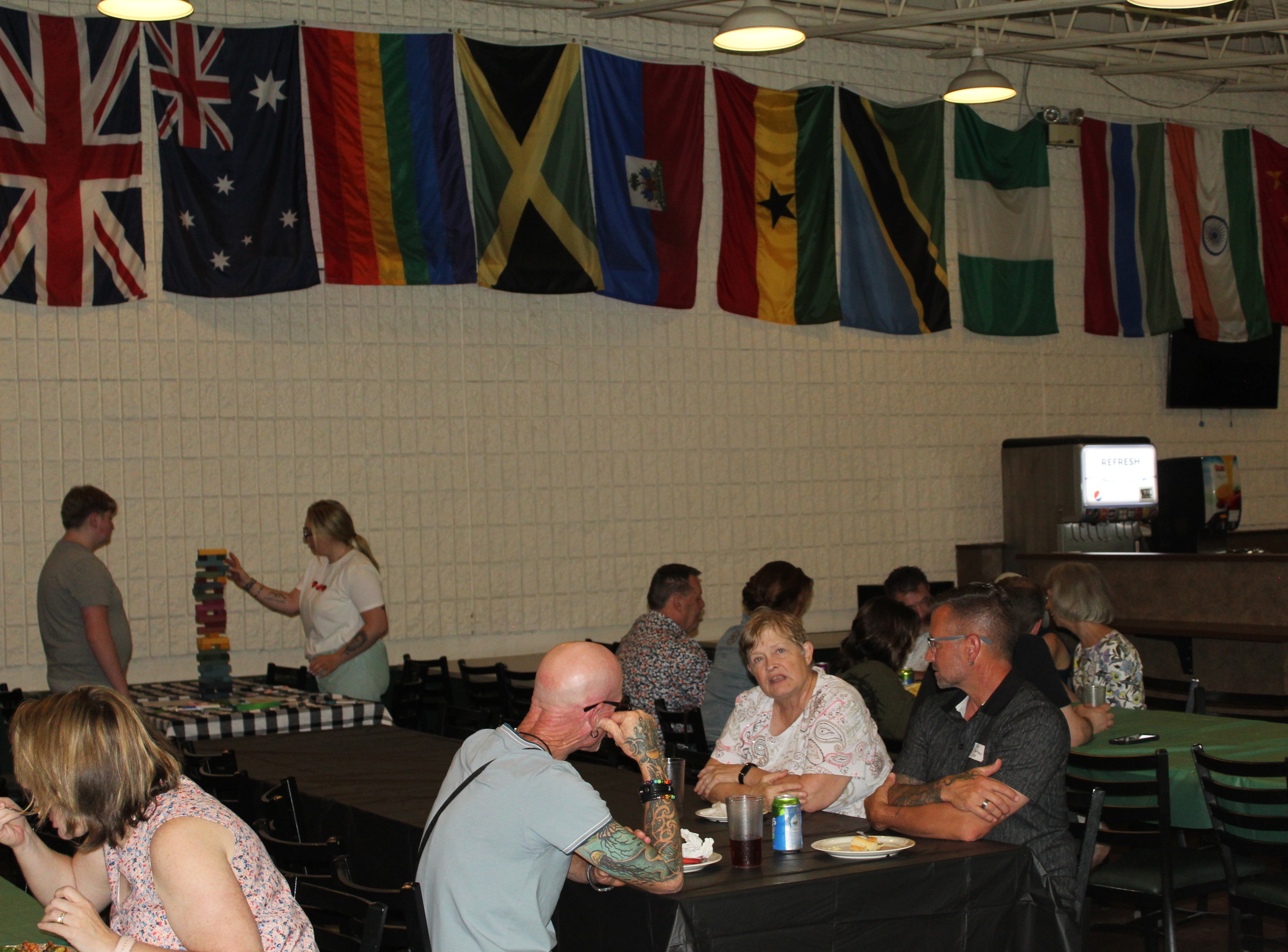 People sit in a cafeteria, eating and talking