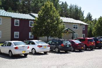 Cars are parked outside the college's residence halls